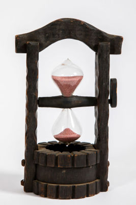 שעון חול בבאר עץ. שעון חול מזכוכית, עם חול ורדרד 
בבאר עץ, מתהפך בהטיה של הידית, 
מודד 5 דקות 