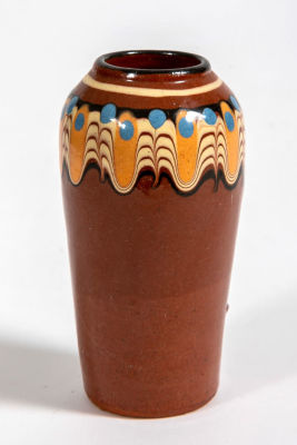 אגרטל קרמיקה בעבודת יד. אגרטל קרמיקה עם גלזורה חומה, 
מעוטר בשוליים בדוגמה נשפכת בגווני כתום 