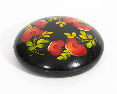 קופסת פפיר מאשה . מעוטרת בפרחים בגווני אדום ירוק בציור יד על רקע שחור, 
קוטר 17 ס"מ, גובה 5 ס"מ 