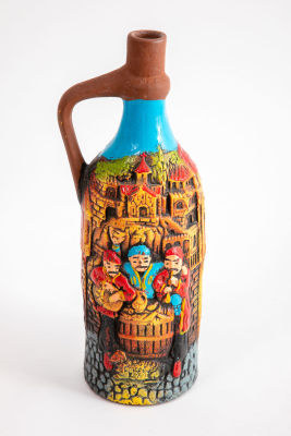 בקבוק זכוכית מעוטר בסצינת קרמיקה כפרית בעבודת יד. גובה 28 ס"מ, קוטר 9 ס"מ