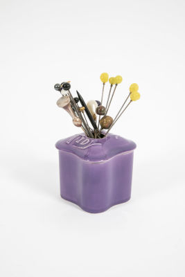 כלי סגול עם סיכות לכובע. סיכות במגוון אורכים, 
על הכלי כתוב Hair tidy. 
מידות הכלי: 8/9 ס"מ