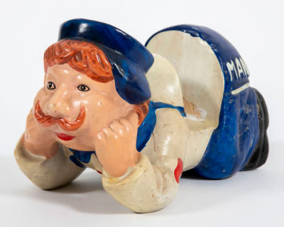 מתקן לניירת בצורת דוור נשען על מרפקיו. פריט וינטג' משעשע, עשוי קרמיקה, צבוע ביד, 
מתקן לדואר 