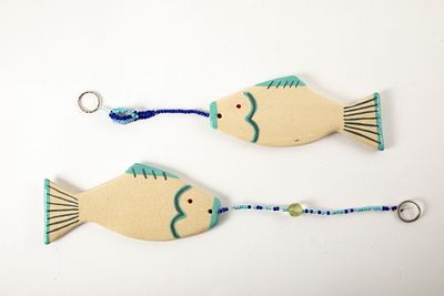 שני דגים מקרמיקה, לתליה. אורך הדג 19 ס"מ 
קילוף מזערי לגלזורה בזנב של אחד מהם