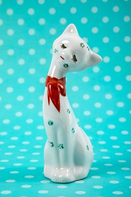 חתול פורצלן לבן חולמני, עם סרט אדום. גובה 16 ס"מ