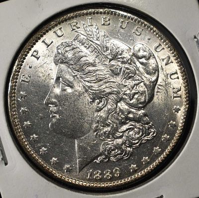1889 MORGAN DOLLAR AU/BU. CHECK OUT OUR UPCOMING AUCTIONS ESTIMATE $120 - $160.