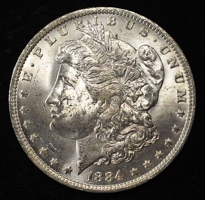1884-O MORGAN DOLLAR BU. CHECK OUT OUR UPCOMING AUCTIONS ESTIMATE $130 - $150.