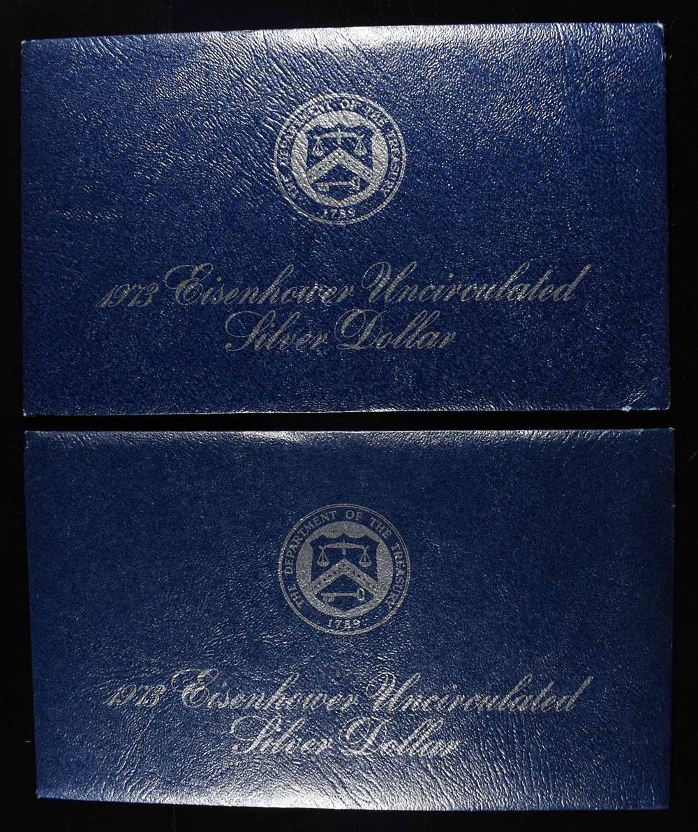(2) 1973 EISENHOWER DOLLAR BLUE PACKAGING. LEADERS IN ON-LINE AUCTIONS ESTIMATE $75 - $100.