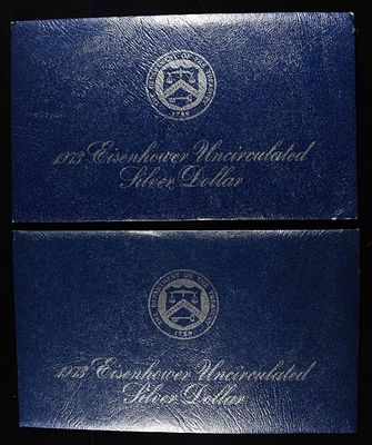 (2) 1973 EISENHOWER DOLLAR BLUE PACKAGING. LEADERS IN ON-LINE AUCTIONS ESTIMATE $75 - $100.