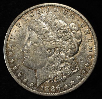 1886-O MORGAN DOLLAR XF/AU. CHECK OUT OUR UPCOMING AUCTIONS ESTIMATE $130 - $150.