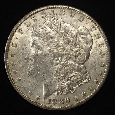 1886-O MORGAN DOLLAR AU. CHECK OUT OUR UPCOMING AUCTIONS ESTIMATE $200 - $250.