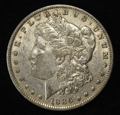 1886-O MORGAN DOLLAR XF/AU. CHECK OUT OUR UPCOMING AUCTIONS ESTIMATE $120 - $150.