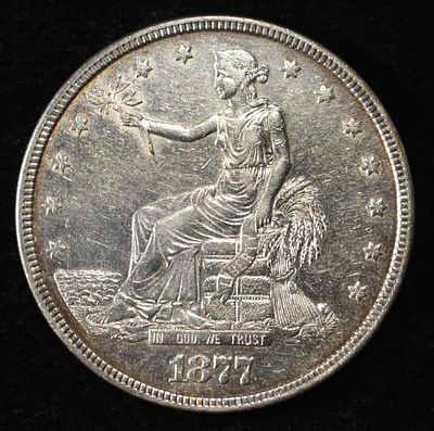 1877 TRADE DOLLAR BU AU. CHECK OUT OUR UPCOMING AUCTIONS ESTIMATE $600 - $700.
