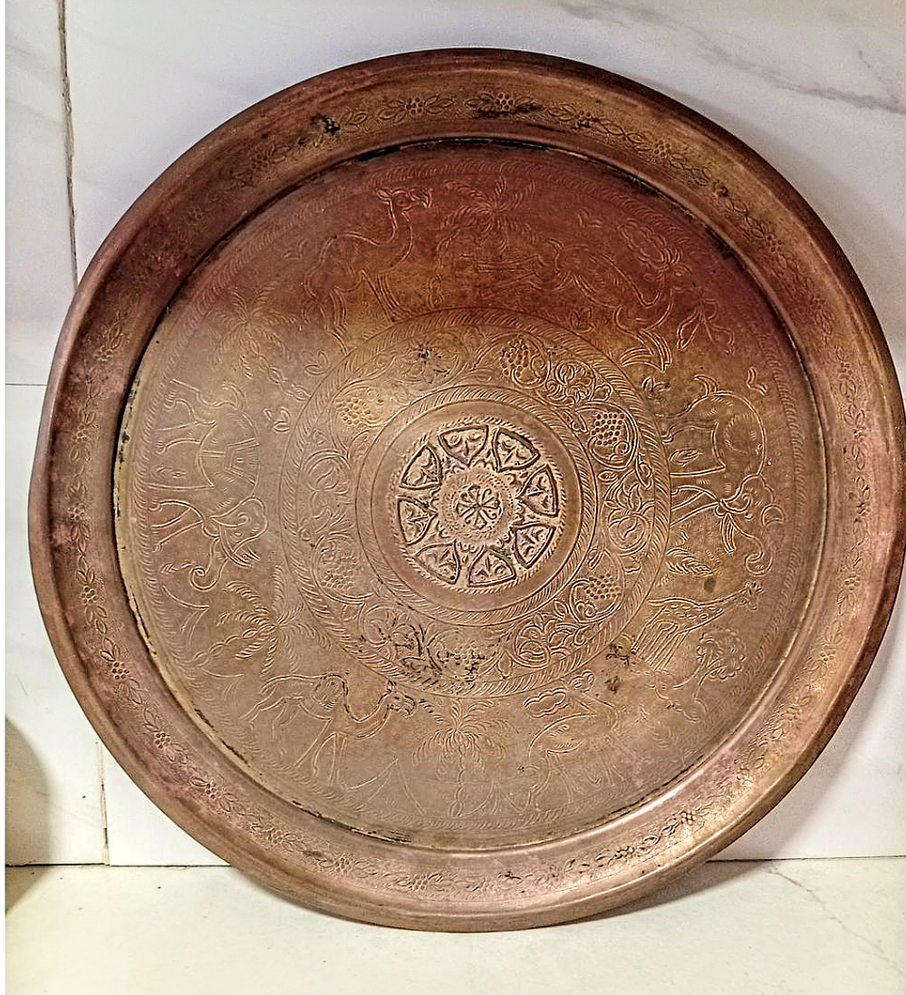 מגש נחושת אדומה הודי ככל הנראה עם עיטורי אומן של פילים גמלים איילות וצמחיה עשירה . 50 ס''מ קוטר 