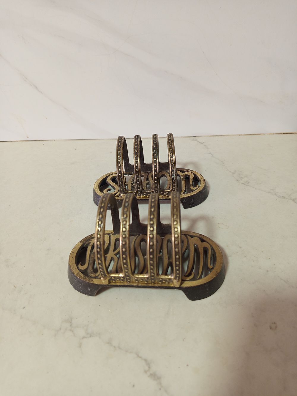 זוג מעמדים מפיות ברונזה . זוג מעמדים למפיות עשוי ברונזה 
כיתוב שלום בלועזית 
גובה 8 ס''מ 
רוחב 15 סמ