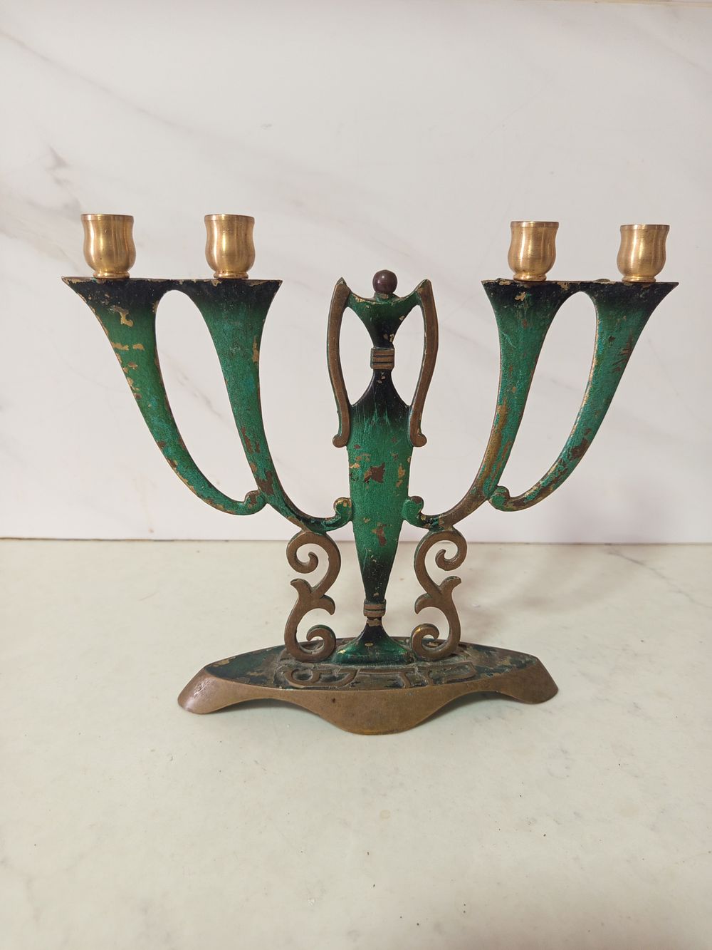מנורה 4 קנים . מנורת ברונזה ארבע קנים 
עם כיתוב 
גובה 20 ס''מ רוחב 21 סמ 
כיתוב צד אחד שבת צד 
