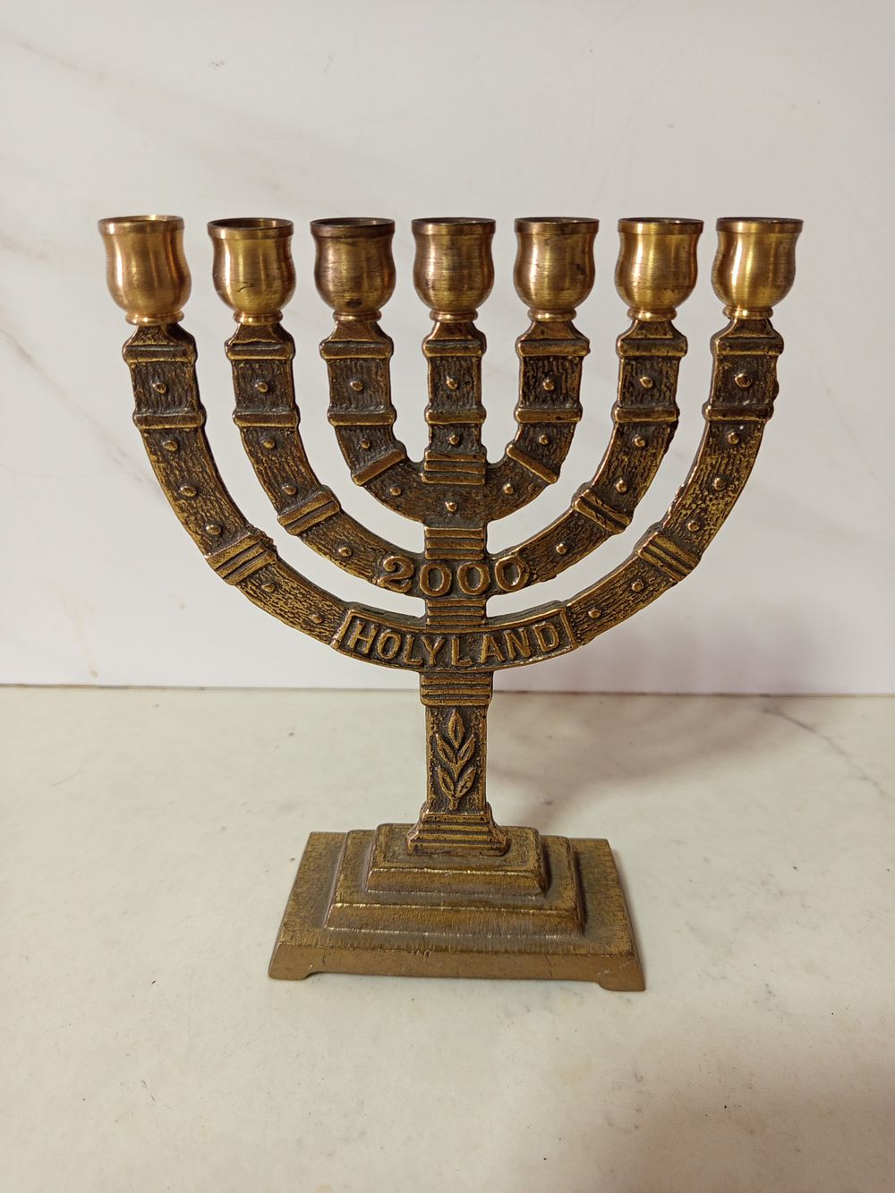 מנורת ברונזה 7 קנים 
כיתוב אנגלית הולילנד 
2000 
גובה 20 ס''מ רוחב 15 ס''מ 
כבדה מסיבית