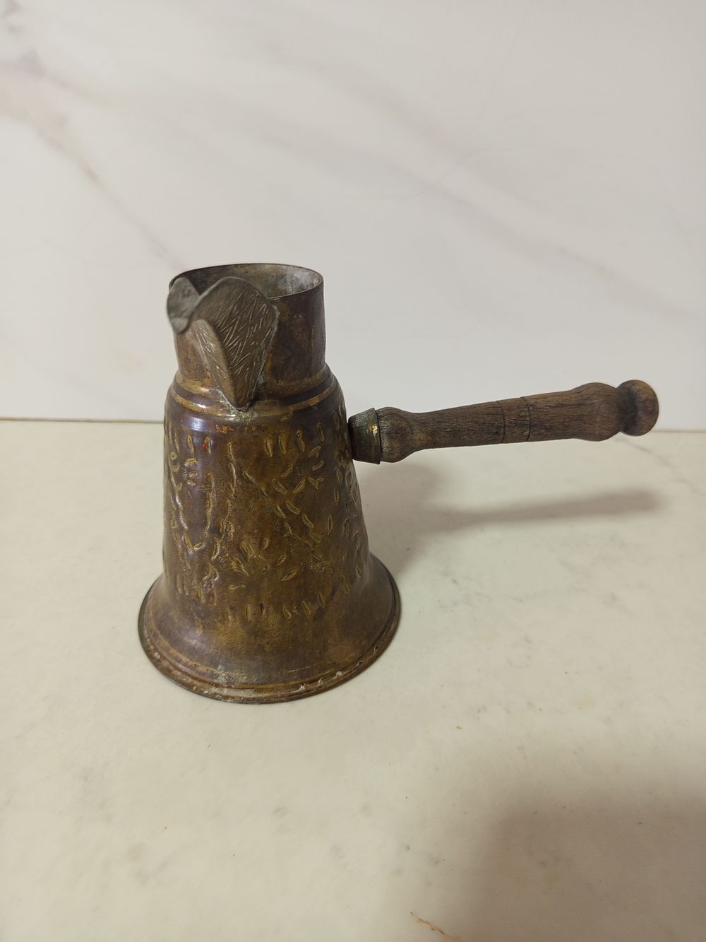 קנקן מזיגה עשוי ברונזה 
גובה 13 ס''מ אורך כולל ידית 20 ס''מ 
יש חריטות עבודת יד