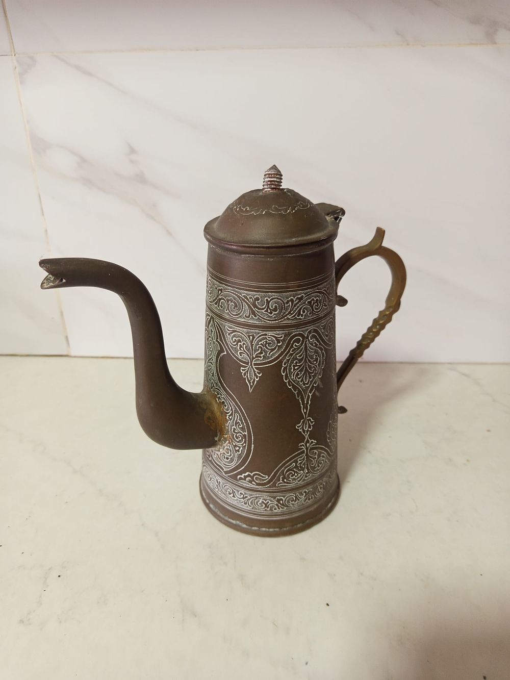 קנקן מזיגה איסלם . קנקן מזיגה עשוי ברונזה עבודת יד מאויירת עשירה חריטות 
איסלמי 
גובה 25 ס''מ 