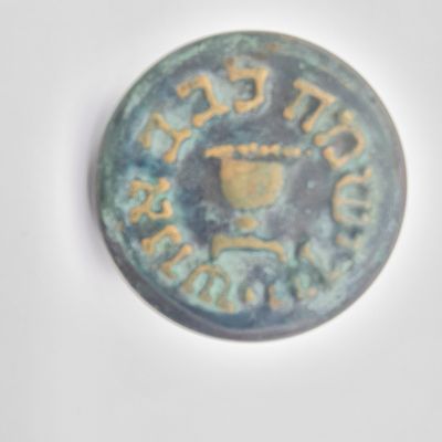 פקק וינטג' לבקבוק יין, עשוי שעם, עץ, וציפוי נחושת עם פטינה ירוקה. כיתוב 'יין ישמח לבב אנוש'