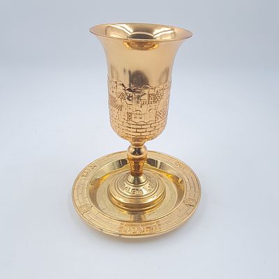 גביע קידוש מהודר עם תחתית, עשוי מתכת מוזהבת, מצב כחדש (מלבד מעט שחיקה בתחתית)
גובה כ 15 ס"מ