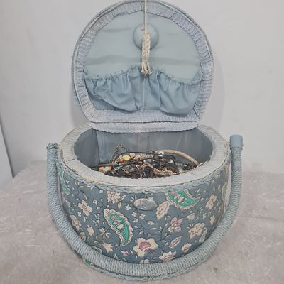 תיק עשוי משילוב עץ ובד, מכיל כמות גדולה של תכשיטים (ערבוב של שרשראות, צמידים ועוד)