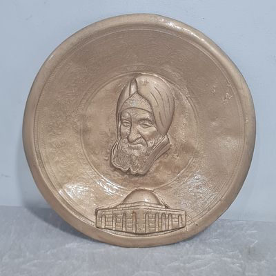 צלחת מתכת לתלייה, עם תבליט דמותו של הבבא סאלי זצ"ל ותבנית מבנה אתר קברו בנתיבות, צבוע מוזהב, מצב 