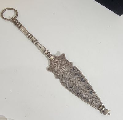 יד לספר תורה מכסף (לא חתום אך נבדק), ישנה דגם תוניסאי, עם כיתוב 
אורך כ 24 ס"מ 
משקל כ 99.3 גרם