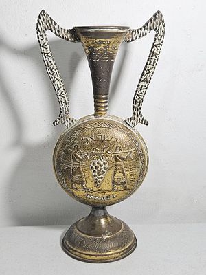 פריט נוי מיוחד ממתכת בצורת אגרטל עם 2 ידיות, תבליט 2 מרגלים נושאים מוט עם אשכול ענבים, ישראל 