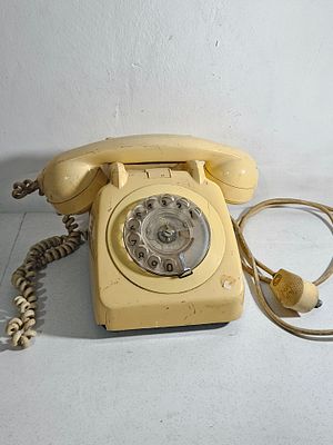 מכשיר טלפון חתום 'משרד התקשורת' שנת 1974, צבע קרם, בלאי שימוש, שבר קטן בפינה, החוגה חוזרת לאט מאד