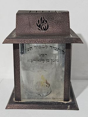 נר נשמה ענק לכבוד הצדיק רבינו נחמן בן פיגא , בית ממתכת מוקף זכוכיות ובתוכו קערת זכוכית גדולה 