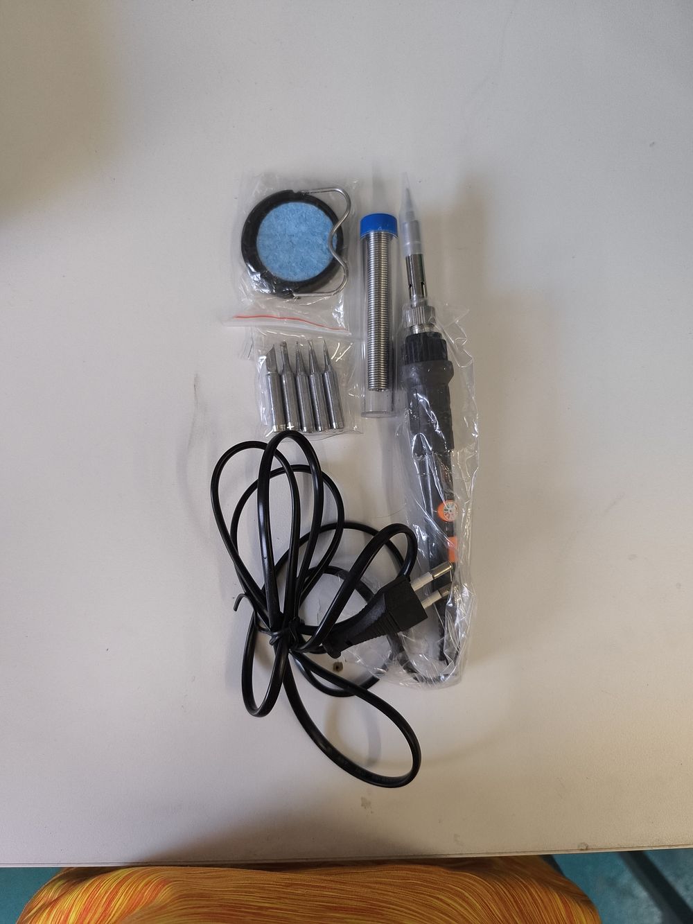 A Lot of Four Items: A Modern Soldering Kit with European Plug and Associated Packaging. This 