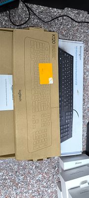 Three Wired Keyboards, including a Logitech K120, and Partially Visible Boxed Smartwatches. This 