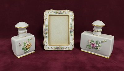 2 bottles and 1 picture frame, in porcelain, polychrome decoration with embossed flowers. With 