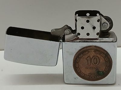 אספנות מצתים: מצית Zippo מקורית העשוי פליז במארז כרום קלאסי
שעל גביו מטבע ישן ישראלי של 10 