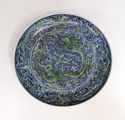 AN ANTIQUE KANGXI FAMILLE VERTE DRAGON CHARGER. The green five toed dragons chasing flaming 