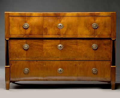 AN EARLY 19TH CENTURY CONTINENTAL BIEDERMEIER COMMODE. The handsome Biedermeier figured walnut 