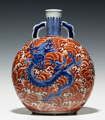 A CHINESE PORCELAIN BLUE, WHITE, COPPER RED DRAGON VASE. The moonflask with slightly flattened 