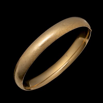 A VINTAGE LADIES 14K GOLD BANGLE WITH CROSSHATCHING. The decorated ladies bangle bracelet is 