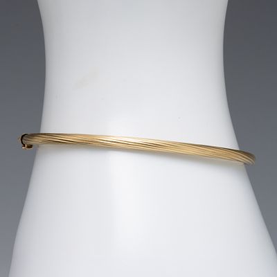 A VINTAGE ITALIAN 14K GOLD TWISTED RIB LADIES BANGLE. Marked 14kt inside near the clasp. 