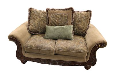Upholstered 2 cushion love seat with carved mahogany frame and decorative throw pillows, in