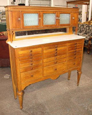 Antique mahogany multi drawer dental cabinet with original milk glass top and glass front