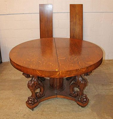 Antique 54" diameter quartersawn oak dining room table with (2) 11" leaves on a carved griffin