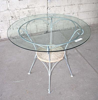 Metal/wicker base glass top bistro table. Metal and wicker base glass top bistro table approx.