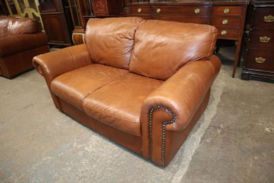 Rust brown leather 2 cushion loveseat approx. 65" w x 40" d x 34" h