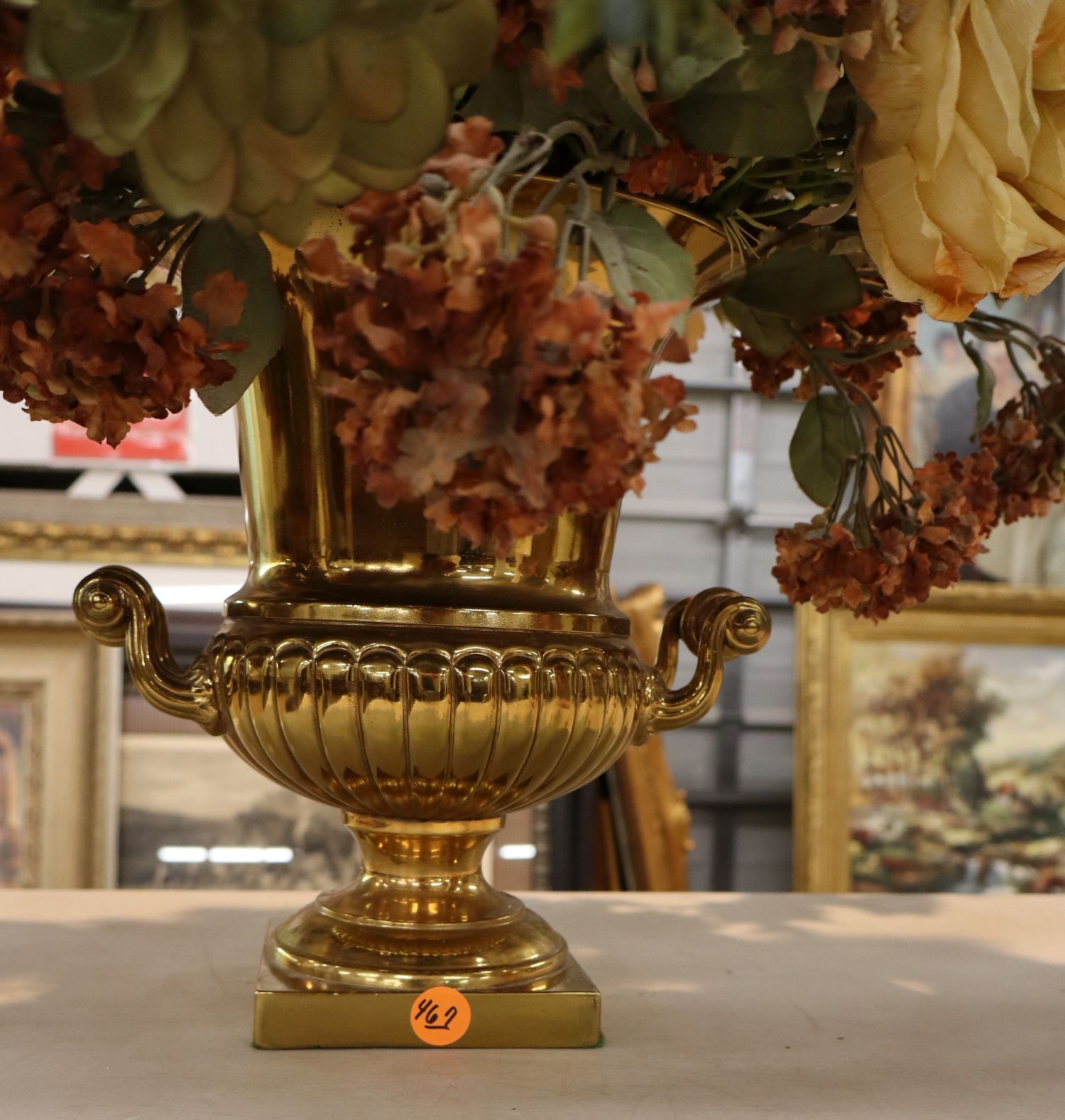 Quality faux floral arrangement in brass double handle vase