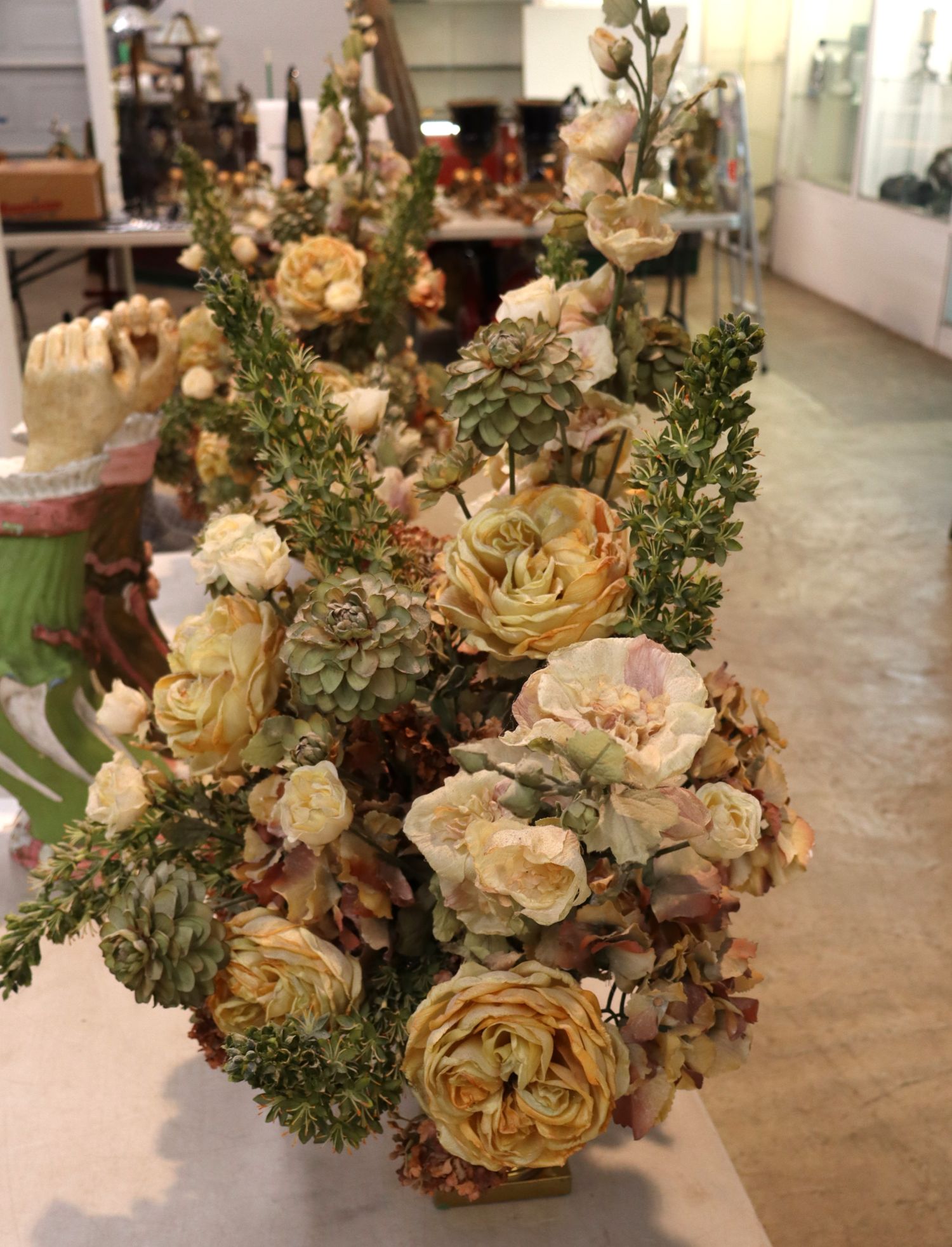 Quality faux floral arrangement in brass double handle vase