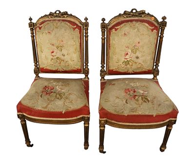 Pair of antique French side chairs with original needlepoint upholstery in carved gold gilt 