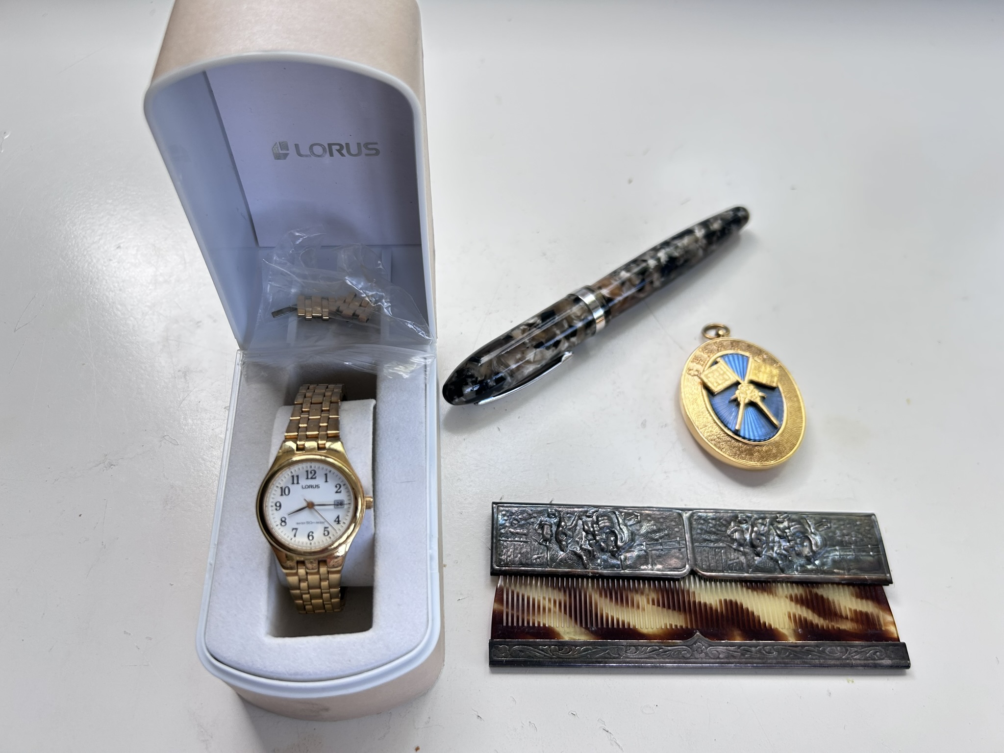 An interesting collectables lot comprising a high end Italian Laban fountain pen crafted in hand turned resin, a mid-century Hans Jensen metal cased pocket comb in great condition, a Masonic provincial standard bearers jewel and a boxed Lorus watch