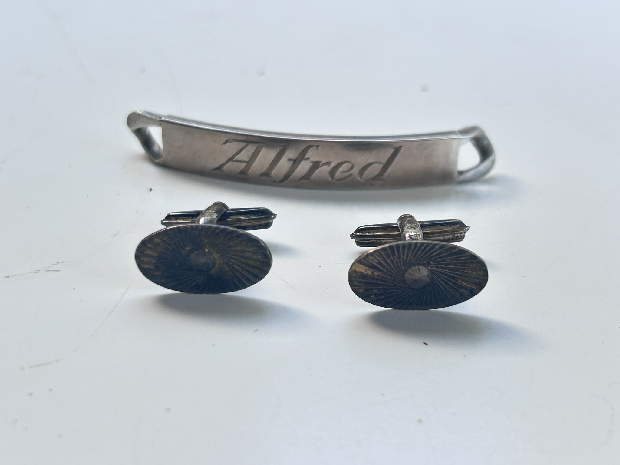 A solid silver hallmarked name tag bracelet section and a pair of silver hallmarked cufflinks, with a combined weight of 20g