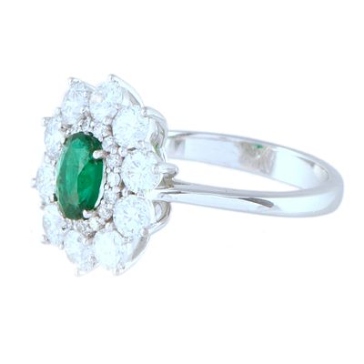15. Diamonds and emerald rosette ring. Made in 18kt white gold, with a central marquise cut 